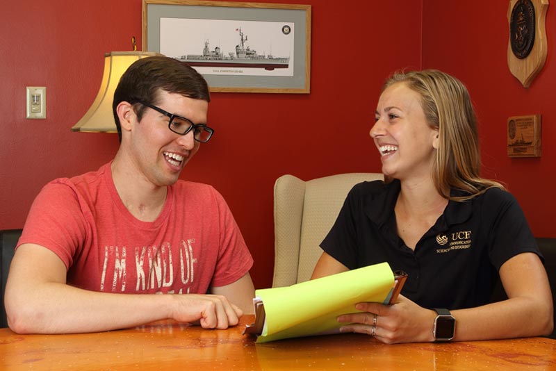 a young UCF student working with a male participant of the Aphasia House