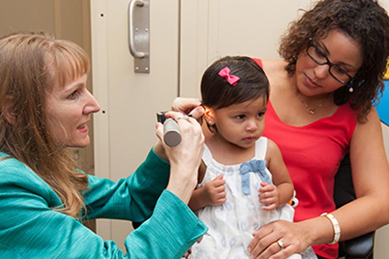 researcher at the UCF Listening Center examining young child's ear