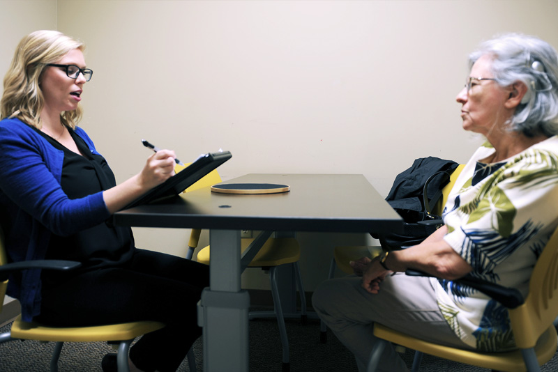 an interviewer at the UCF Listening Center asking questions to an older participant
