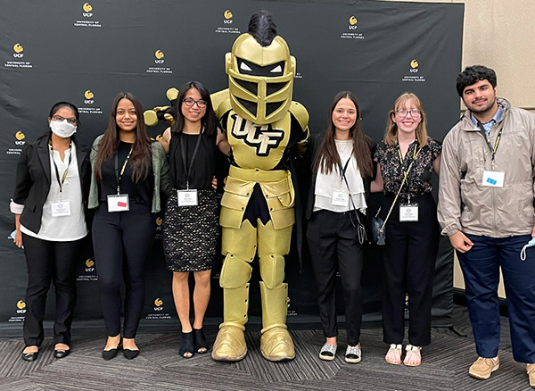 student researchers standing next to Knightro
