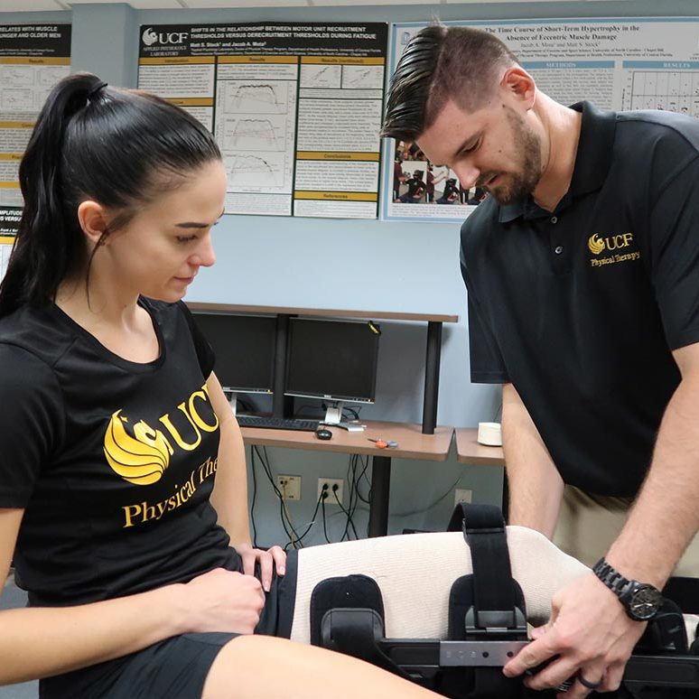 Physical Therapy student helping another student into her knee brace