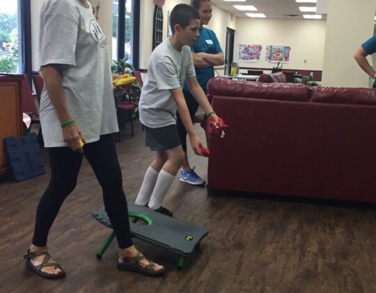 kids and adults playing a game with bean bags