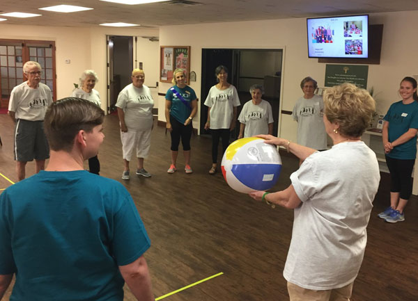 elderly participants playing a game where they pass a beach ball