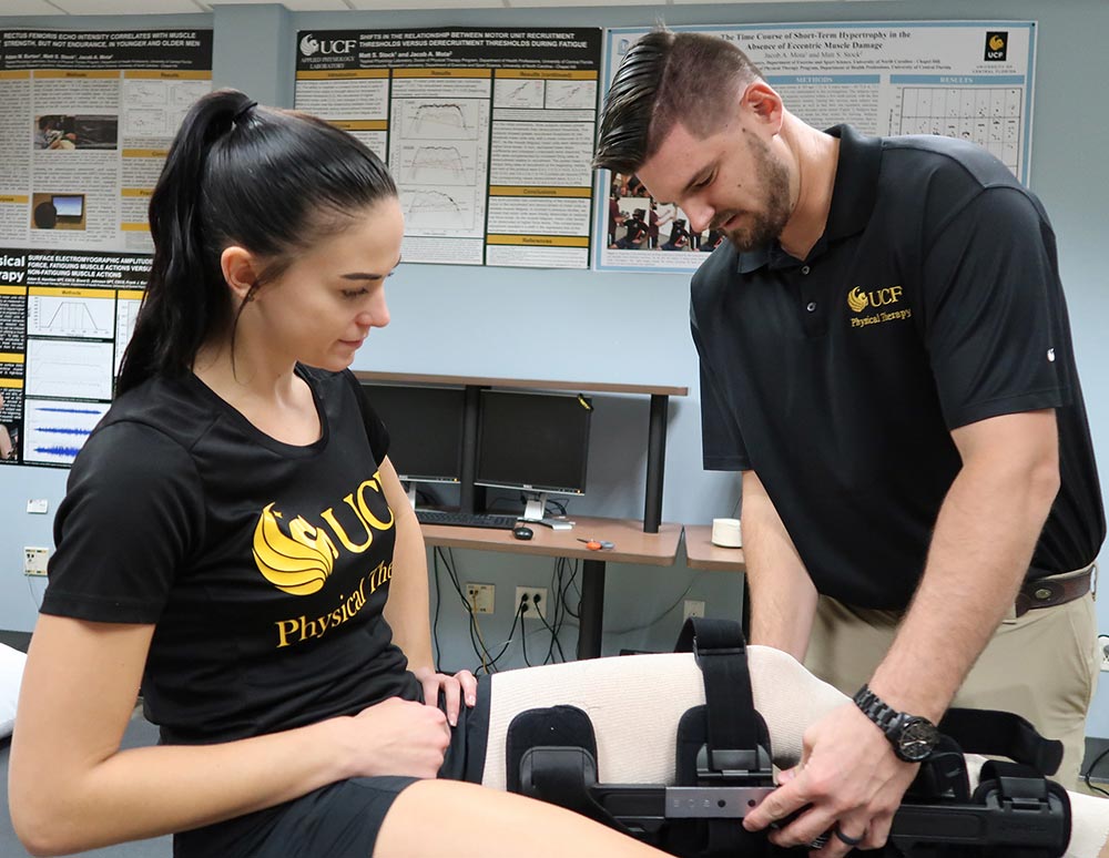 physical therapist helping a student put on her large knee brace