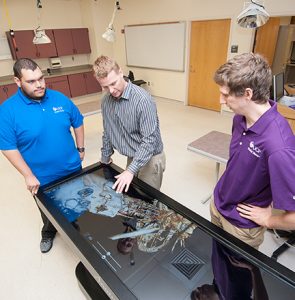 Patrick Pabian showing D.P.T. students Christopher Atkinson and Kyle Perkins The Anatomage.