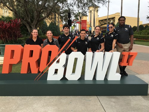 Athletic Training students Emily Rice, Alina Verdeja, Dan Goinzalez, Matt Ramirez, Darian Brothers, Tonya LaPointe and Jordan Rowley in front of the Pro Bowl 17 sign.