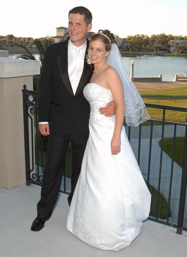 Adam Casebolt in a suit hugging Melissa Casebolt in a wedding dress.