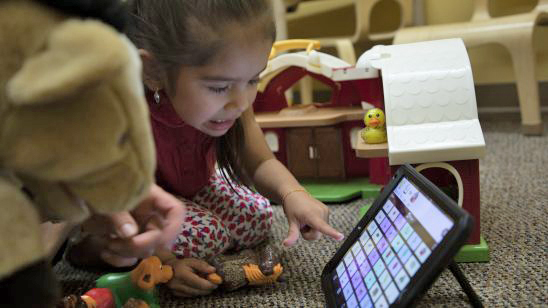 A child learning how to use apps as a communication tool.