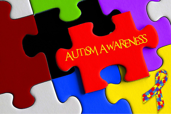Colorful puzzle pieces together with one on top reading "autism awareness"