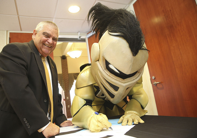 Dean José Fernández signing papers with Knightro