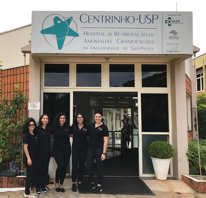 Five UCF graduate students in front of a Craniofacial Treatment Center.