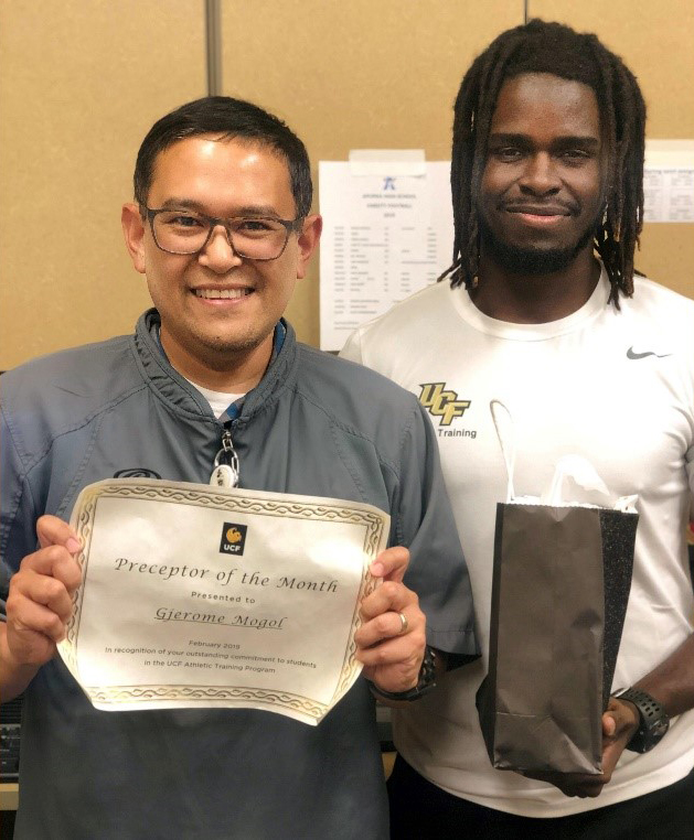 Gjerome Mogol holding a certificate and Mo Louidor holding a gift bag.