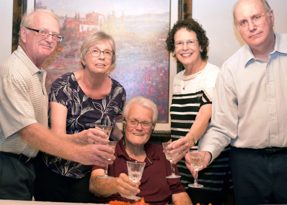 Group of people holding glasses of champagne raised in a toast