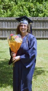 Hannah Rodriguez holding flowers in cap and gown.