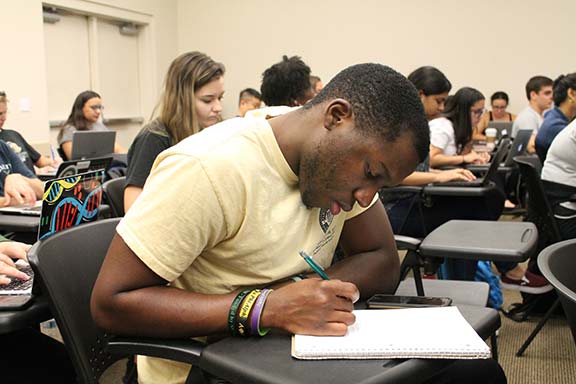 A man writing notes during a class.