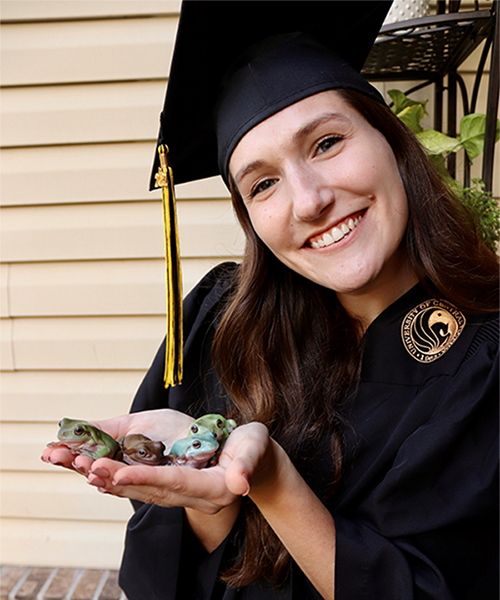 Kaitlyn Vidal holding four frogs.