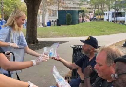 woman giving water to person