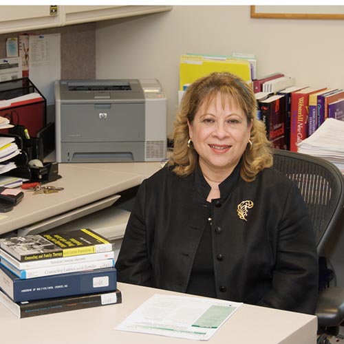 Ana Leon sitting in office.