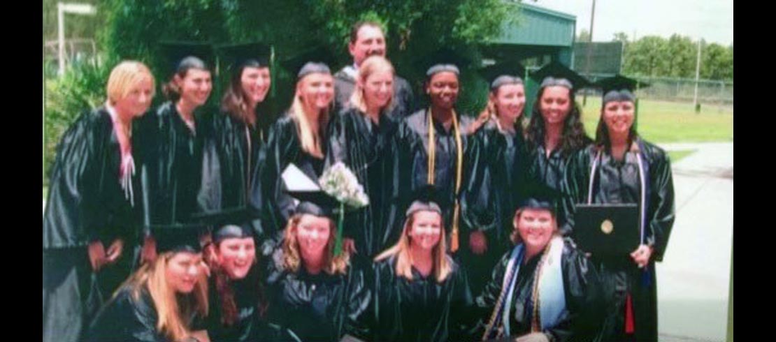 David Cassidy with a group of students in cap and gowns.