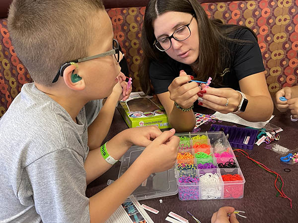 group of campers around a booth making bracelets