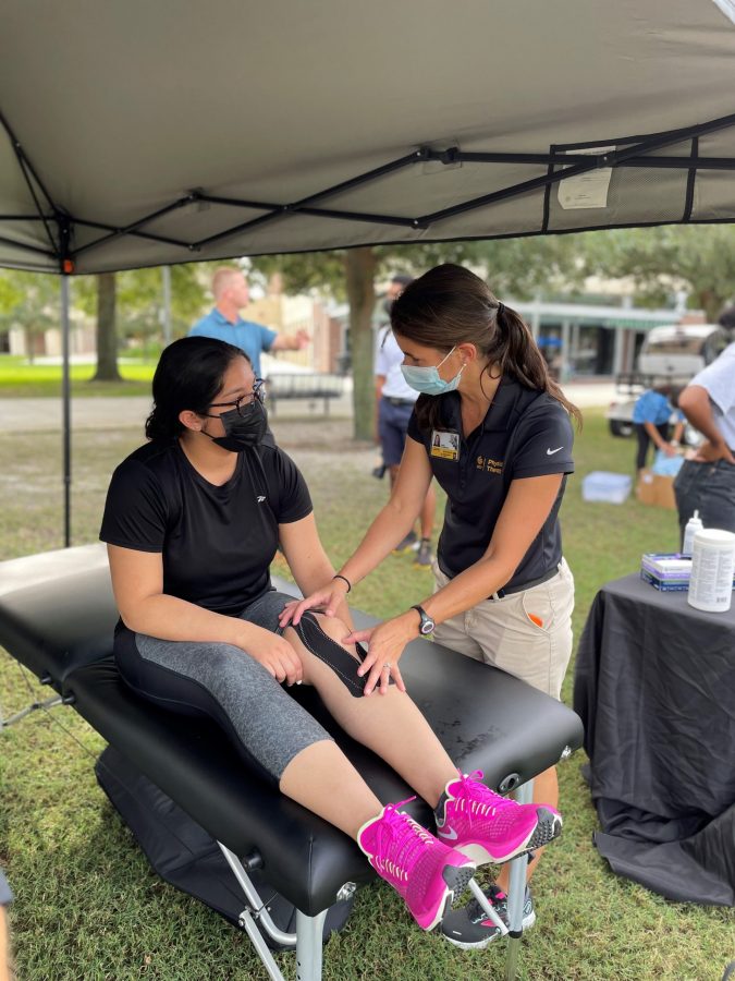 Clinical Assistant Professor Randi Richardson working on a patient's knee outside under a tent