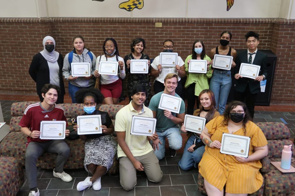 Fourteen students holding up certificates for completing the new Interdisciplinary Projects in Health Professions course.