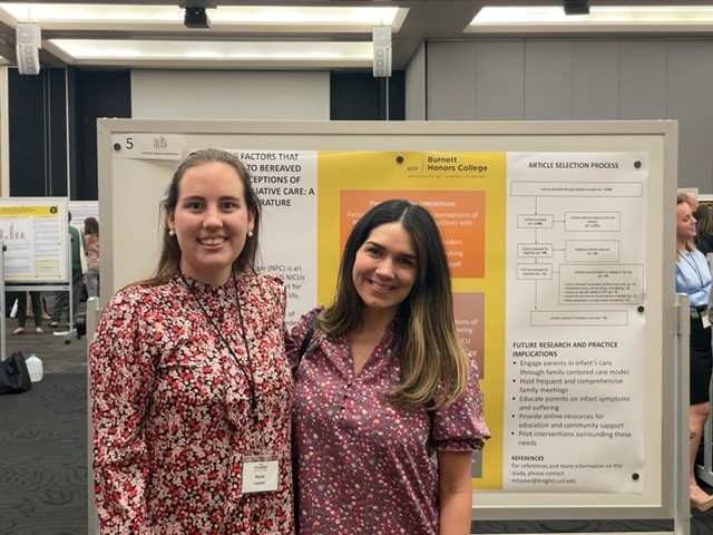 Student and faculty standing in front of research poster