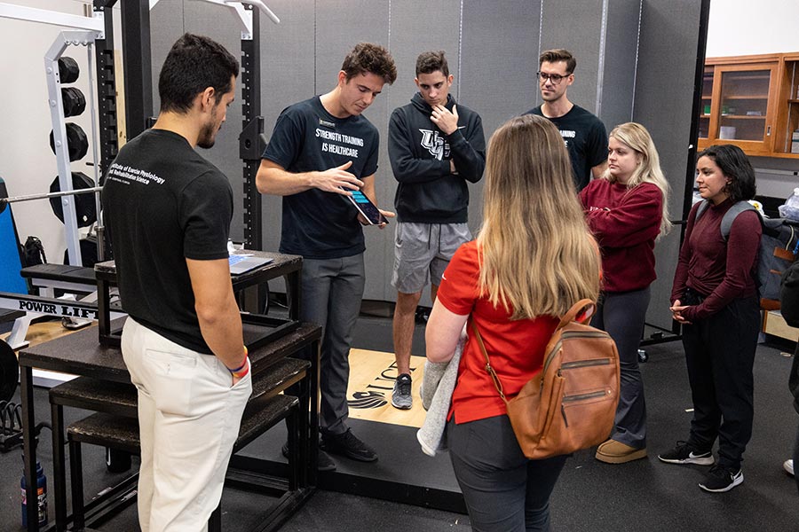 UCF Physical Therapy students Juan Rodriguez (left), Daniel Sheldon (center), and Scott Stockunas (right) engage with attendees at the IEPRS Lab Crawl.