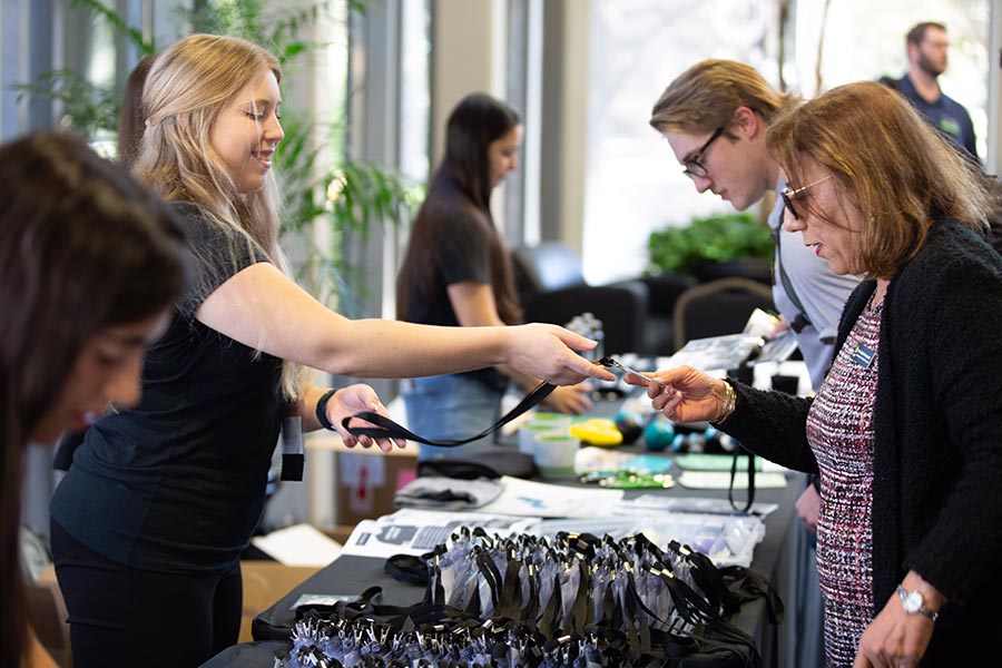 MAT student Emily Paulson greets attendees at the conference registration booth.