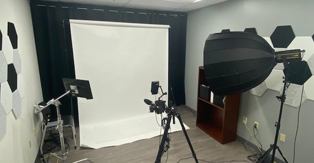 A photoshoot set up with a backdrop and cameras.