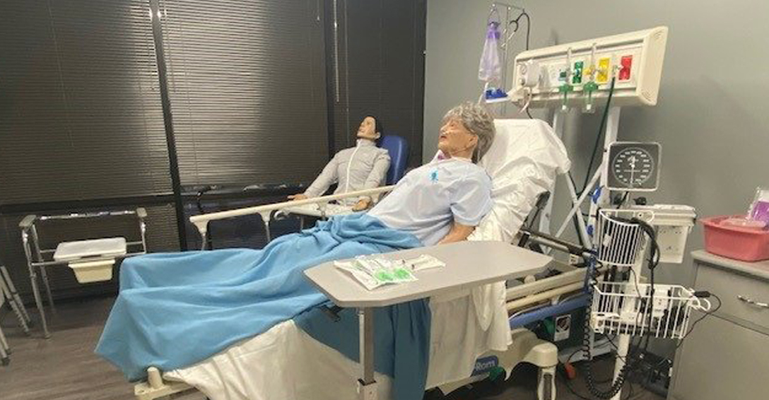 A manikin laying in a hospital bed in the Innovation Center.