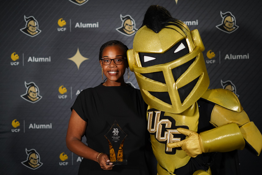 Atiyah Appline standing with UCF Knight mascot