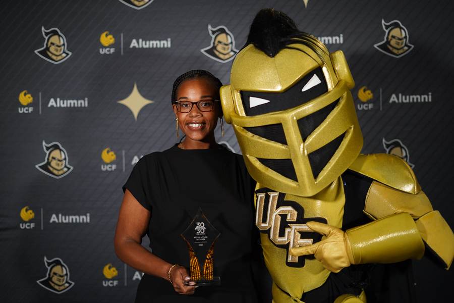 Atiyah Appline standing with Nitro, UCF Knight mascot