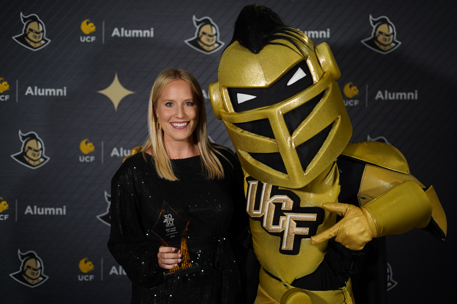 Emily Allen standing with Nitro, the UCF Knight mascot.