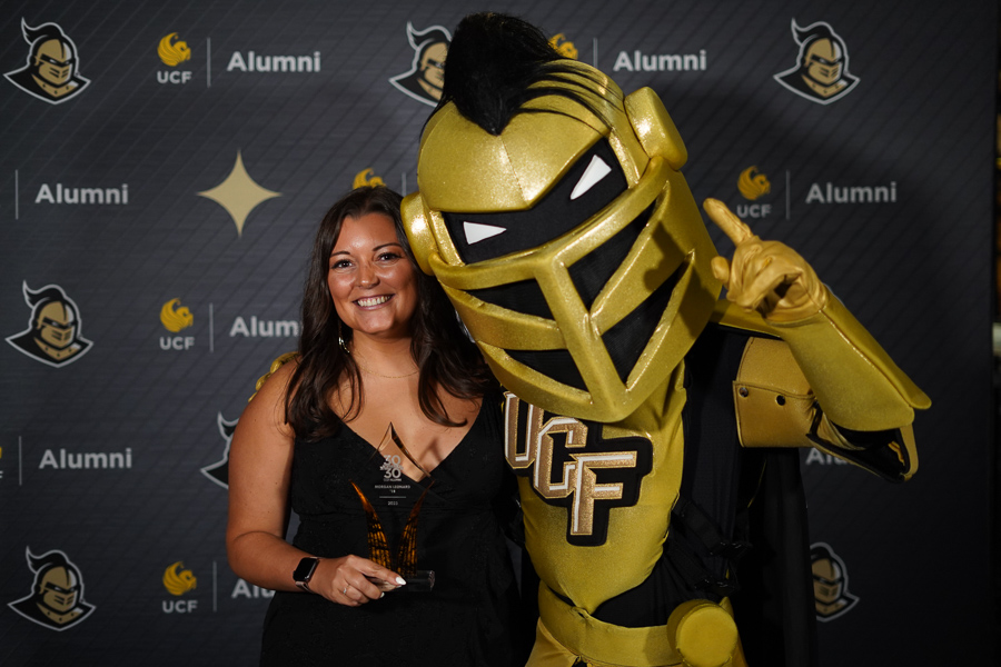 Morgan Leonard standing with Nitro, the UCF Knight mascot.