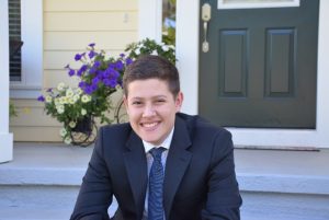 Parker Baro on the front steps of a house in a suit