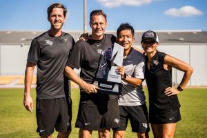 Keisuke with UCF soccor coaches holding a trophy