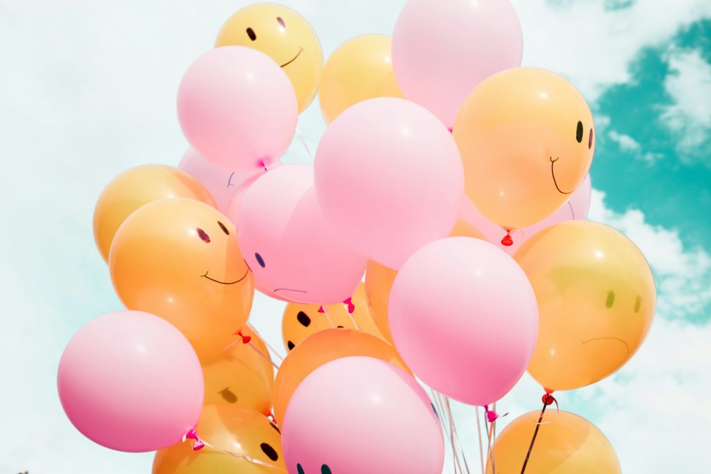 Orange and pink balloons with smiles and frowns
