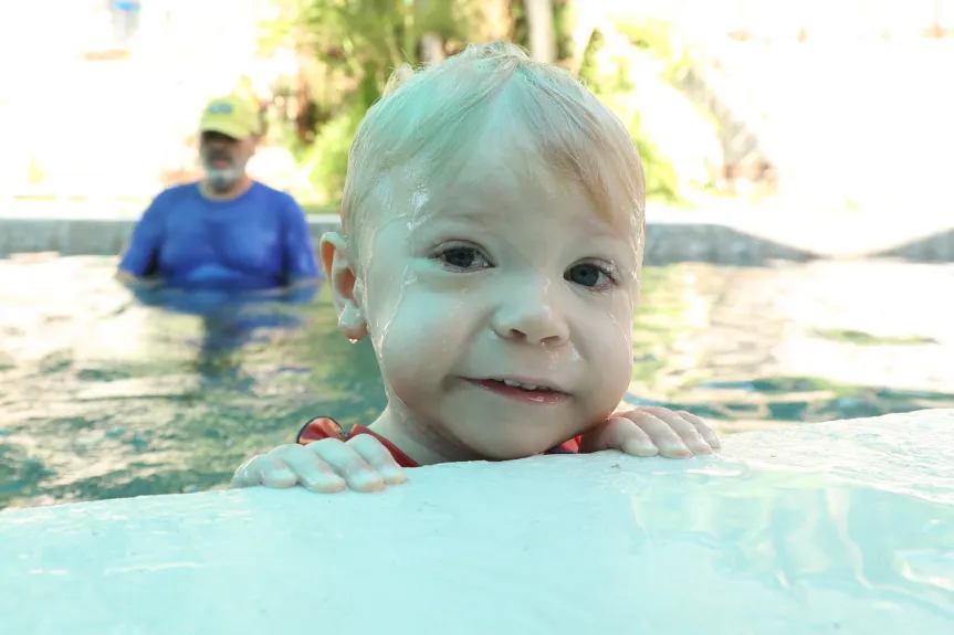 Lucas Davies age 3, pulls himself to the edge of the pool during a swim lesson with swim instructor Geoff Dawson at Dawson’s backyard pool in Longwood on Monday, Aug. 19, 2024. (Rich Pope, Orlando Sentinel)