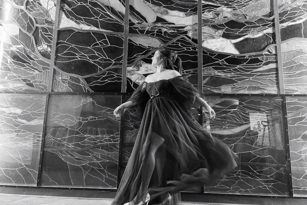 Elizabeth Grauer dances in front of a stain glass window.