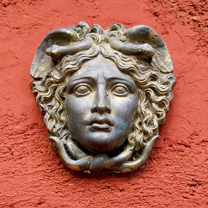 Greek / Roman Woman Face on a red painted wall