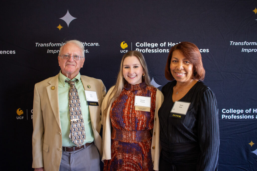 Marisol Freytes smiles while standing between a smiling man and woman